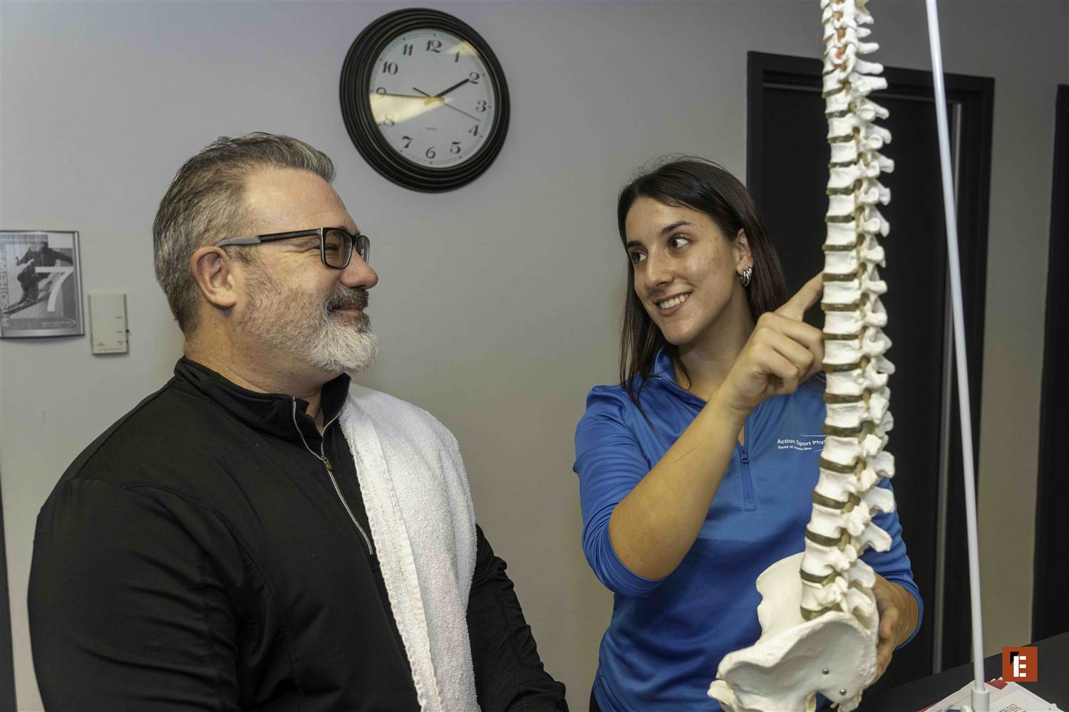 Un patient âgé et une jeune clinicienne rient ensemble